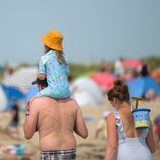 Eine Familie läuft an einem Nordsee-Strand entlang.