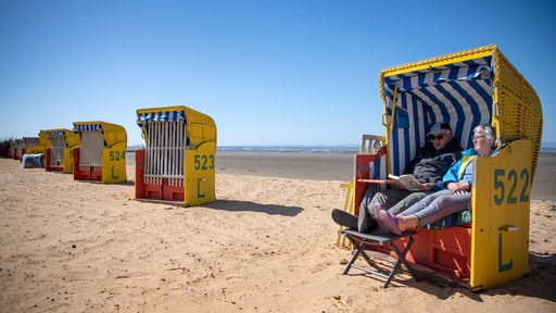 Ein Rentnerpaar sitzt in einem Strandkorb.