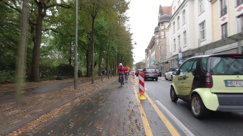 Eine Straße in BremensInnenstadt, die sich PKW's und Radfahrer*innen teilen.