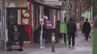 Eine Frau mit Kopftuch auf einer Straße in Gröpelingen.