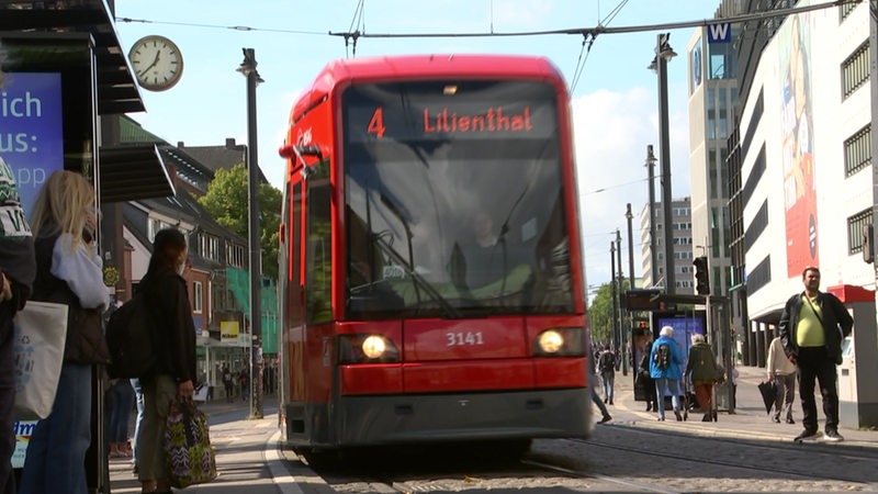 Eine Straßenbahn der Linie 4 fährt in den Haltestellenbereich an der Domsheide ein.