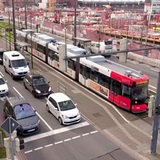 Zu sehen ist eine Straßenbahn und mehrere Autos in der Überseestadt.