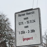 Ein Baustellenschild gibt eine Straßensperrung minutengenau an.