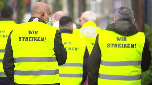 Zahlreiche Personen tragen gelbe Westen mit der Aufschrift "Wir streiken!".