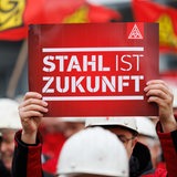 "Stahl ist Zukunft" steht auf dem Plakat eines Arbeiters bei einer Kundgebung der IG Metall.