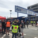 Menschen in Warnwesten stehen zusammen und unterhalten sich.