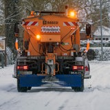 Ein Schneepflug räumt eine Straße.