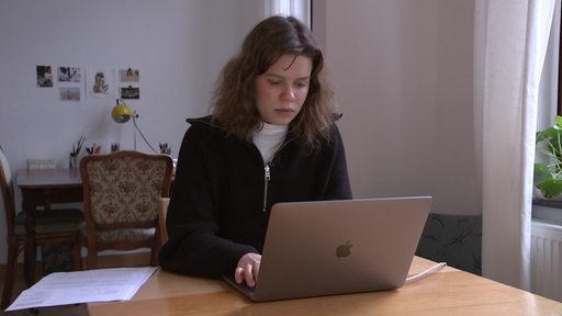 Eine Kundin sitzt an ihrem Computer.