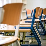 Hochgestellte Stühle sind in einem Klassenraum zu sehen.