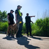 Einsatzkräfte der Polizei stehen bei der Suche nach dem vermissten Arian mit einem Spürhund an der Oste.