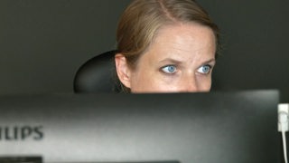 Susanne Kollmann schaut über ihr Laptop