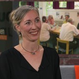 Eine Frau lächelt in die Kamera.