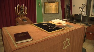 Innenraum einer Synagoge mit jüdischen Utensilien.