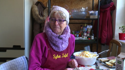 Christiane Grobbin sitzt an einem Tisch und prepariert das Essen für die Syker Tafel.