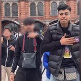 Drei junge Männer stehen vor dem Fankfurter Hauptbahnhof.