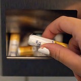 Eine Frau nimmt auf einer Toilette kostenlose Tampons aus einer Metallbox. 