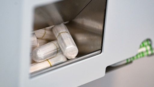 Tampons und Binden liegen in einem Automaten.