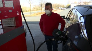 Ein Mann tankt sein Auto bei hohen Spritpreisen an einer Tankstelle.