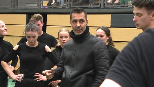 Grün-Gold-Trainer Roberto Albanese ist nach dem Training umringt von seinem Tänzerinnen und Tänzern und hält eine Ansprache.