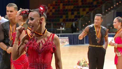 Eine Tänzerin vom TSG Bremerhaven freut sich über ihre Medaille bei der Deutschen Meisterschaft im Lateinformationstanz. 