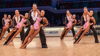 Die Lateinformation des Bremer Grün-Gold-Clubs bei einer Pose der Choreografie "Emozioni 2022" in der Bremer Stadthalle.