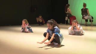 Mehrere Kinder führen eine Tanzinszenierung auf.