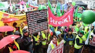Streikende Menschen halten Plakate, Fahnen und Transparente hoch. Um den Druck im aktuellen Tarifstreit weiter zu erhöhen, rufen die Verdi, der Beamtenbund dbb und die Gewerkschaften im DGB zum Warnstreik auf.