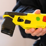 Ein Polizeibeamter hält einen Taser 7 in der Hand