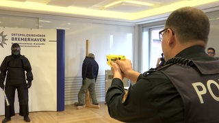 Ein Polizist schießt auf einen verkleideten Mann
