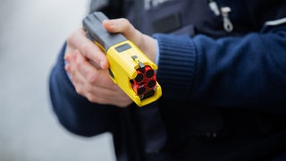 Ein Polizeibeamter demonstriert ein Distanzelektroimpulsgerät (oder auch Taser) im Trainingsmodus ohne scharfe Munition.