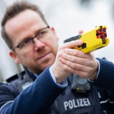 in Polizeibeamter demonstriert einen Taser im Trainingsmodus ohne scharfe Munition. 