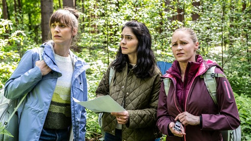 Drei Frauen haben sich verirrt und stehen hilflos im Wald.