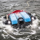 Ein rot-blaues Gerät mit einem Kabel daran schwimmt auf dem Meer.