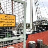 Ein Schild an einem Gitter vor dem Segelschiff "Elbe" weißt auf Reparaturarbeiten hin