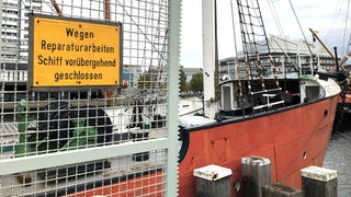 Ein Schild an einem Gitter vor dem Segelschiff "Elbe" weißt auf Reparaturarbeiten hin