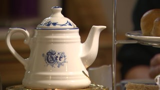 Eine weiße Teekanne aus Porzelln mit der Aufschrift Tee: