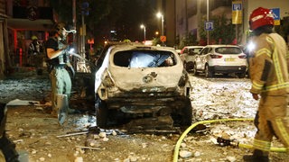 Demolierte Autos und Trümmer auf einer Straße in Tel Aviv