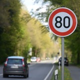 Ein 80er-Schild steht am Fahrbahnrand einer Landstraße