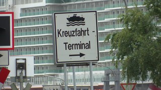 Ein einem Schild wird auf das Kreuzfahrtterminal hingewiesen.
