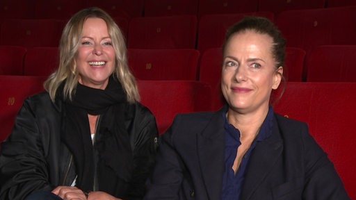 Zwei Frauen sitzen im Theater und geben ein Interview.