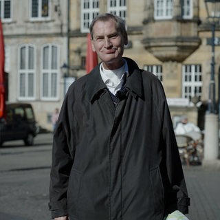 Willi Stümer steht auf dem Bremer Marktplatz 
