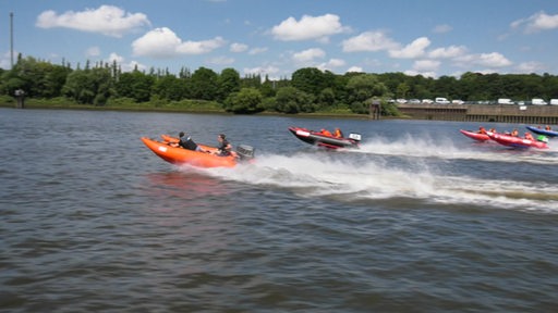 Vier Motorboote fahren auf der Weser ums Rennen.