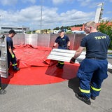 Peronen in blauer Kleidung arbeiten am Aufbau eines mobilen Beckens.