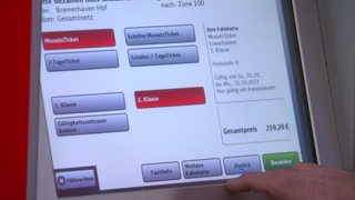 Ein Mann bestellt ein Ticket am Automaten der Deutschen Bahn.