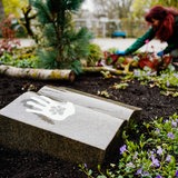 Eine Friedhofsgärtnerin arbeitet auf dem Friedhofsgelände an einem Grabfeld für Menschen und Tiere.