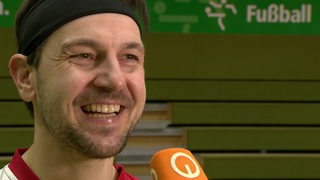 Tischtennis-Spieler Timo Boll strahlt beim Interview nach dem Spiel gegen Werder Bremen.