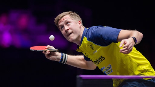 Tischtennis-Profi Mattias Falck konzentriert sich während des Aufschlags auf den Ball in der Luft.