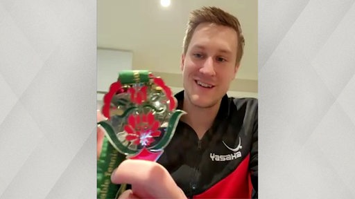 Tischtennis-Vizeweltmeister Mattias Falck zeigt seine Silbermedaille in die Kamera.