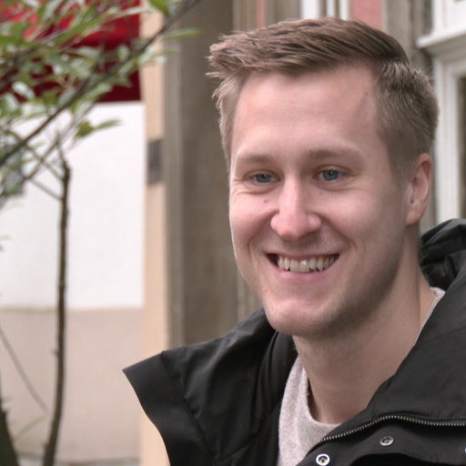 Werders Tischtennis-Spieler Mattias Falck lächelt, während er bei einem Interview in einem Schnoor-Café sitzt.