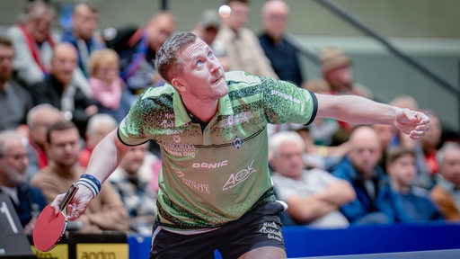 Werders Tischtennis-Profi Mattias Falck fokussiert sich beim Aufschlag auf den hochgeworfenen Ball.